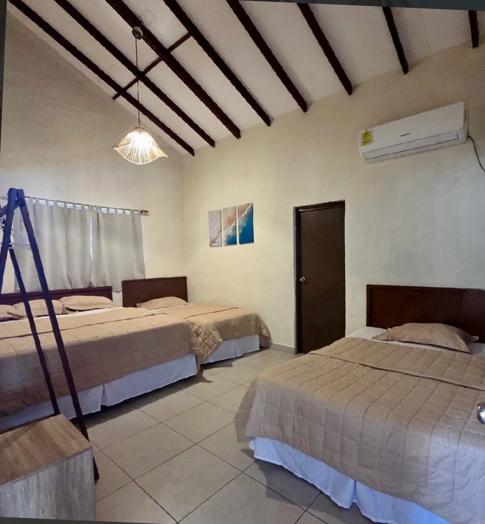 Habitación de Rancho Palmar con varias camas y aire acondicionado