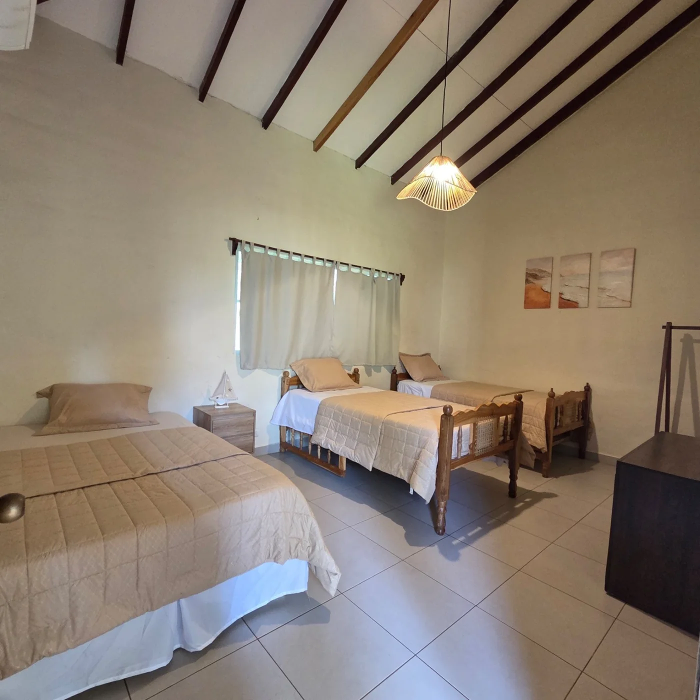 Habitación espaciosa de Rancho Palmar con varias camas, ventana y techo alto